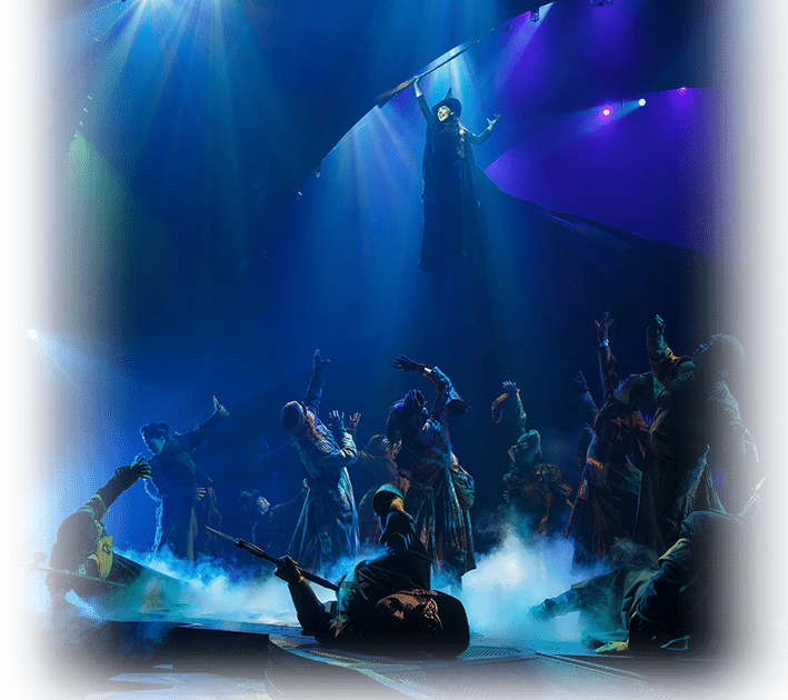 Elphaba Holding Her Broom in the Air, Defying Gravity With the Guards Below Her