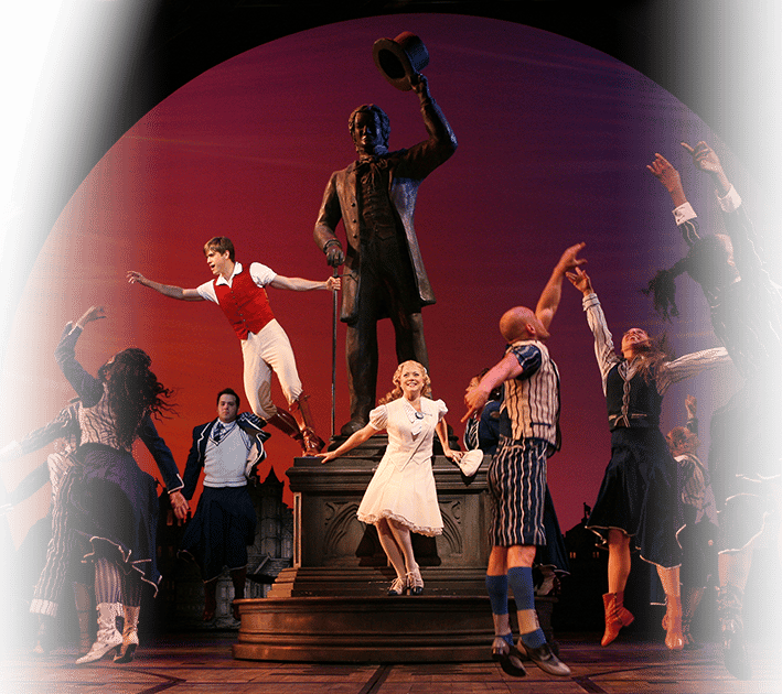 Ensemble Members Dancing Around a Statue that Glinda and Fiyero are Standing On